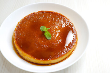 Delicious caramel custard with a glossy caramel top, served on a white plate. Perfectly lit, smooth texture, and minimal background. ideal for menus, blogs, packaging, or dessert features. Copy space