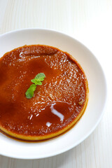 Delicious caramel custard with a glossy caramel top, served on a white plate. Perfectly lit, smooth texture, and minimal background. ideal for menus, blogs, packaging, or dessert features. Copy space