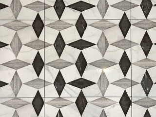 Close up of black and white tiles in random diamond shape pattern. Suitable for floor tiles and walls. For toilet and kitchen floor. Seamless background texture.