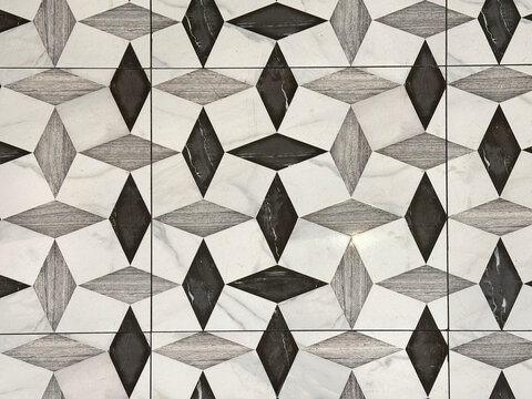 Close up of black and white tiles in random diamond shape pattern. Suitable for floor tiles and walls. For toilet and kitchen floor. Seamless background texture.