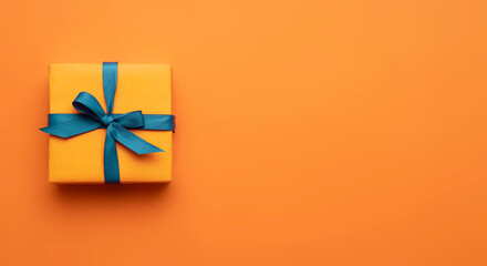 Orange color gift wrap decorated with blue ribbon top vie on empty space...