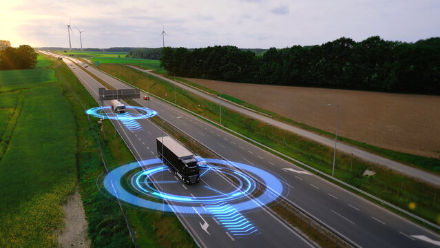 Autonomous driverless trucks with trailers, without a driver, remote control artificial intelligence transport cargo on highway. Smart transportation concept of the future, automated transportation.