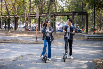 Two people riding scooters in a park