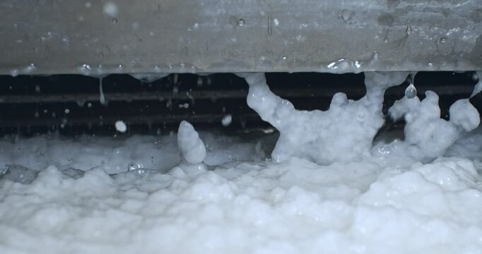 Super Slow Motion Close-Up of Wet Paper Pulp Dropping from Industrial Machine During Handmade Paper Manufacturing Process in Traditional Workshop Environment at 1000 fps.