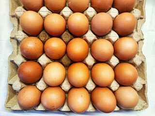 Fresh brown eggs neatly arranged in a carton for sale at a local market