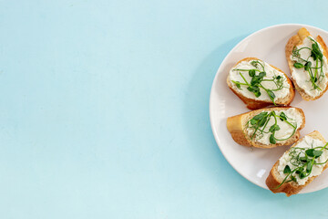 Plate of sandwiches with cream cheese and micro greens peas. Healthy food, top view