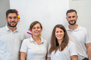 Four friendly Caucasian physiotherapists standing together in a healthcare facility