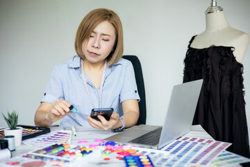 Fototapeta premium Designer is using a smartphone on her desk