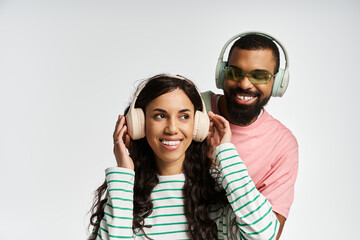 Stylish couple enjoys music together in playful harmony indoors during a bright afternoon
