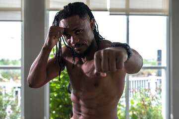 Portrait strong muscular black muay thai boxer training thai boxing  in gym