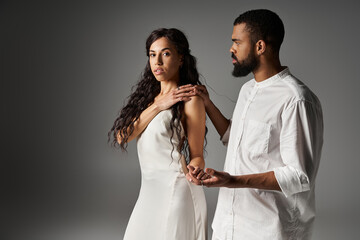 Stylish couple expressing love and connection in a modern setting under soft lighting