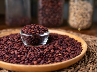 Organic uncooked seeds dark red brown lentils.
