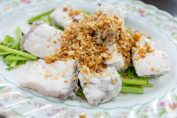 Top view of Steamed sea bass with dipping sauce, focus selective