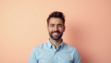 Smiling man. Smiling cheerful man with beard blue shirt standing peach