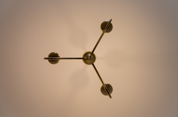 Chandelier style electric light fitting on a ceiling seen directly from below. Landscape view.
