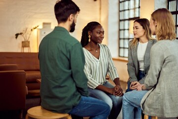 Obraz premium Diverse Group Engaged in a Supportive Talk in a Cozy Room Setting