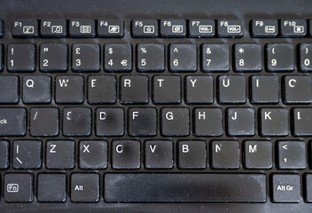 Close up of black computer keyboard. Old and worn. No branding.