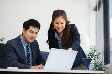 Business team analyzing documents, graphs, and data with a laptop, tablet, and smartphone. Collaboration, strategy, and success in a modern office.