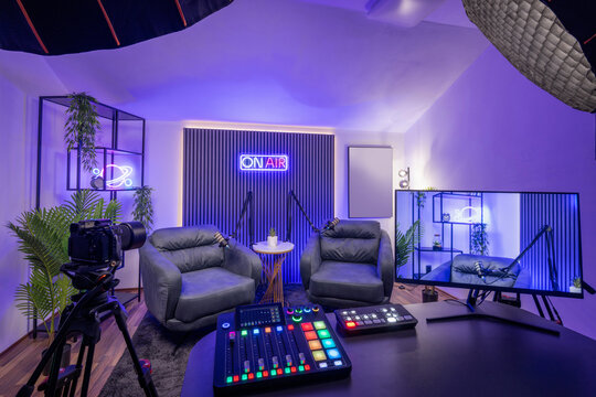 Modern podcast recording studio with pContemporary podcast room with studio lighting, ideal for audio content creation.rofessional lighting