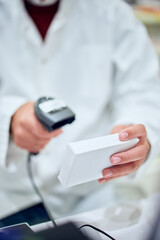 Pharmacist Scanning Medication Box in a Professional Pharmacy Setting