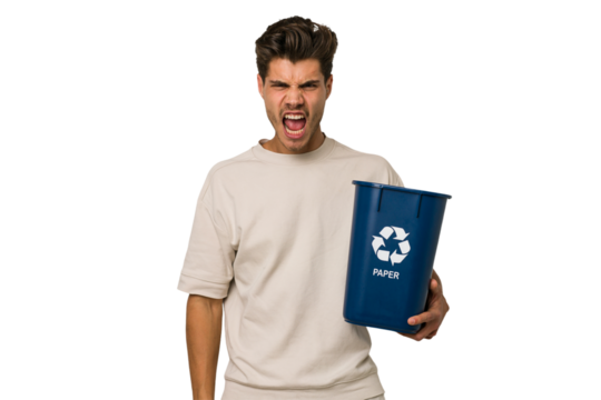 Young caucasian man holding a paper trash for recycle screaming very angry and aggressive.