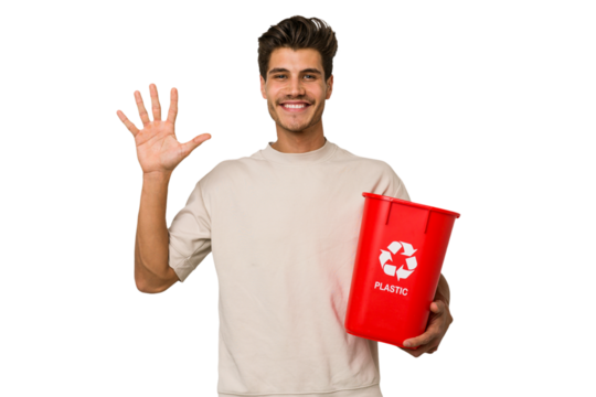 Young caucasian man holding a plastic trash isolated smiling cheerful showing number five with fingers.