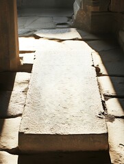 Obraz premium A stone walkway with sunlight shining through the entrance of an ancient building or temple ruin