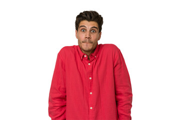 Fototapeta premium Young handsome caucasian man isolated on white background shrugs shoulders and open eyes confused.