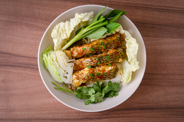  The fish is infused with a flavorful blend of chili and garlic, making it irresistibly appetizing. It's served with a variety of fresh vegetables.