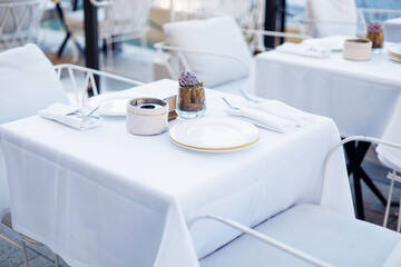 Elegant dining setup with white tablecloth and decorative centerpiece in an upscale restaurant