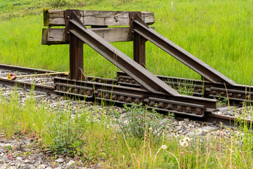 Railroad buffer surrounded by green meadows.