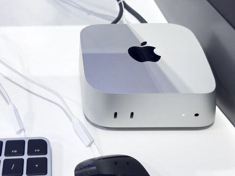 Calgary, Alberta, Canada. May 4, 2025. A silver Mac Mini computer with a black Apple logo. A keyboard and mouse.