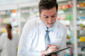man pharmacist checks and arranges medicines on pharmacy shelves, emphasizing precision and responsibility in healthcare services. The scene highlights the daily operations in a modern pharmacy.