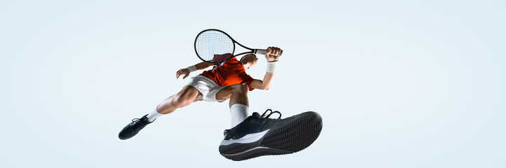 Bottom view of male tennis player reaches high to serve ball with full body stretch from low angle against white studio background. Concept of sport, game, tournament, practice, youth © master1305