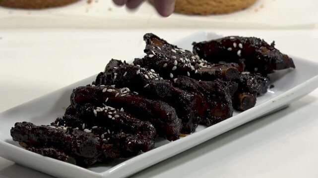 A backyard barbecue features perfectly smoked beef ribs with a rich, caramelized glaze. Friends gather to enjoy great food and lively conversation on a sunny afternoon.