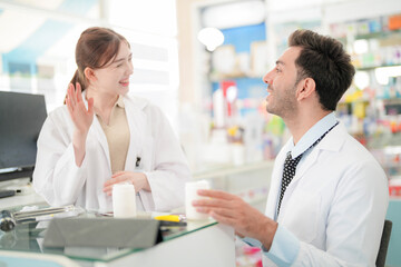 team man and woman pharmacist inspects a medication bottle, ensuring accuracy in prescription filling. pharmacists in patient safety and careful medication handling. operations in retail pharmacy.