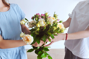 Little boy gives the girl a bouquet of flowers. Birthday party.	