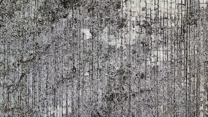A close-up shot of a weathered concrete surface, showing cracks, imperfections, and a rough texture. This image could be used for backgrounds, textures, and design elements. 