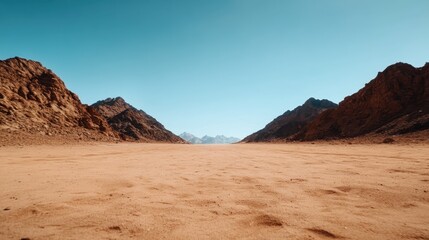 Naklejka premium The open terrain appears framed by majestic mountains and a bright blue sky, highlighting the stark yet beautiful contrasts in nature's landscape.