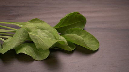 Bundle of fresh spinach isolated on wooden background. Vegan food lifestyle concept, Copy space.