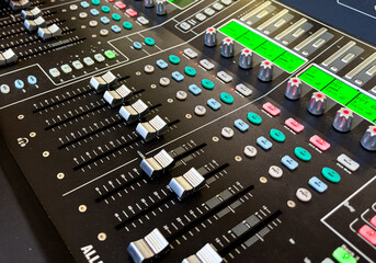 Sliders and buttons on Audio Mixing Desk at live event..