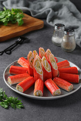 Crab sticks stuffed with rice, egg and green onions on gray background © Anzhela