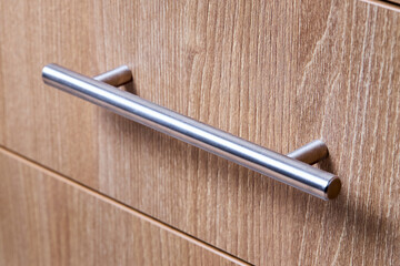 Rectangle shaped kitchen cabinet with stainless steel brushed handles close up selective focus...