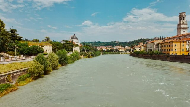 Vibrant flow of River Adige winding past stone embankments in Verona, Veneto, Italy