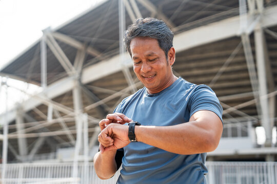 Mature man wearing sportswear using Smart Watch Showing Heart Rate Monitor. Old man with Technology for health and sport mode. Exercise and take statistics to develop your potential