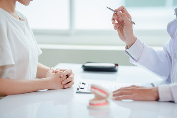 Male doctor or dentist writing report working with tooth x-ray film, model and equipment used in the treatment of dental and dentistry at workplace