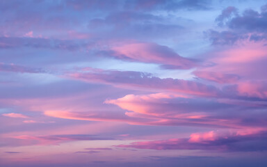 Obraz premium Soft pink and purple clouds fill the sky.
