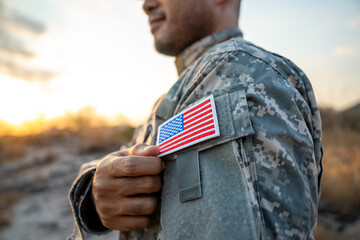 Us Army veteran honors Veterans Day. Man soldier adjusts the US military patch before duty. A US...