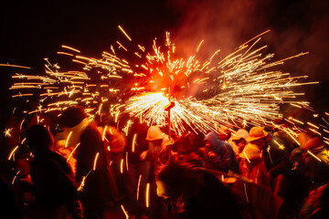 People running with fireworks during correfocs in catalonia