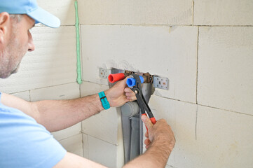 A plumber is meticulously sealing a plumbing connection with tools, illustrating the careful...